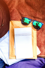 sunglasses lie on the things collected on the trip. empty notebook for writing.