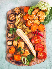 grilled vegetables and chicken pieces in lettuce roll on rye tortilla