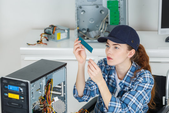 young woman fixing a computer hard drive