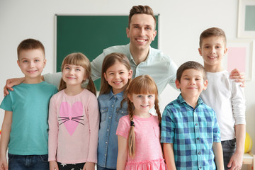 Cute little children with teacher in classroom at school