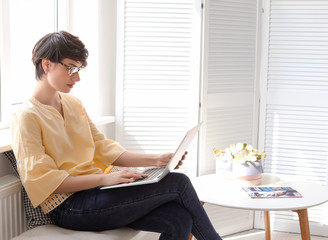 Young woman working with laptop at home