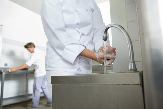 worker in the kitchen washing hands