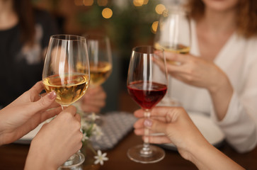 Young people with glasses of delicious wine at table