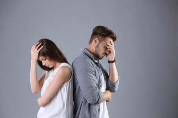 Upset young couple on grey background. Relationship problems