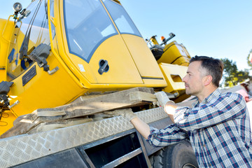 Fototapeta na wymiar construction worker controls of lifting crane in truck