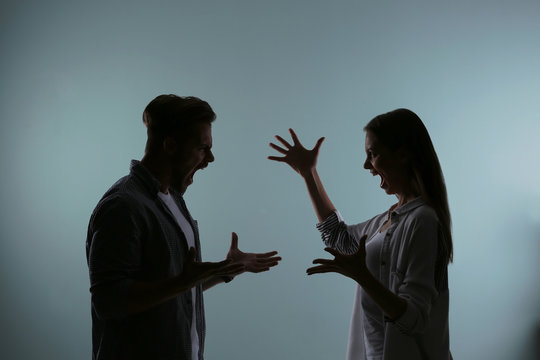 Silhouette of couple having argument on color background. Relationship problems