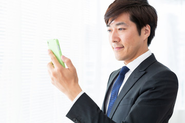 スマホを見るミドル男性　ビジネス