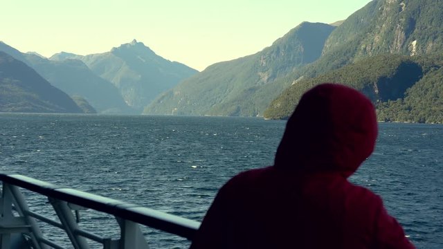 Passenger stands on cruise ship. New Zealand Doubtful sound