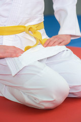 Fototapeta premium boy stands in white kimono with a yellow belt