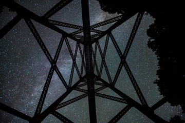 The Milkyway galaxy shining bright over an abandoned railway trestle in the midwest 