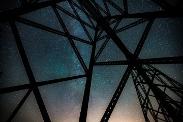 The Milkyway galaxy shining bright over an abandoned railway trestle in the midwest 