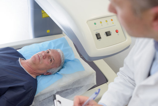 male patient ready to undergo mri assisted by doctor