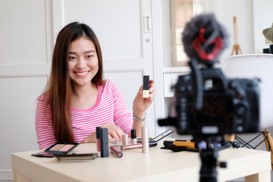 Young asian woman beauty blogger showing how to make up video tutorial, vlog concept, people and technology communication