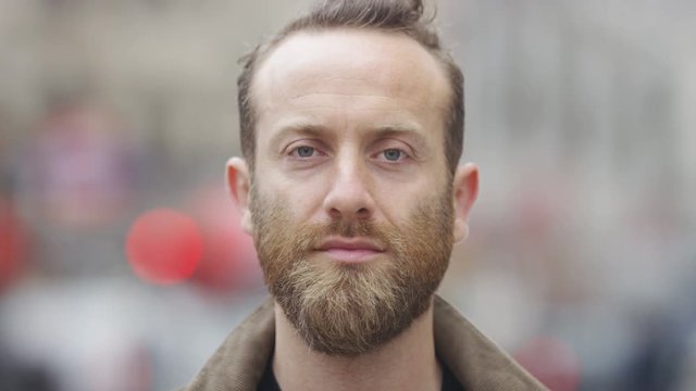 Bearded male in the street looking straight to camera 