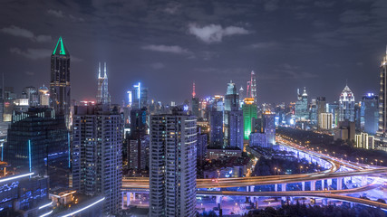 Obraz premium aerial view of buildings and highway interchange at night in Shanghai city