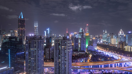aerial view of buildings and highway interchange at night in Shanghai city