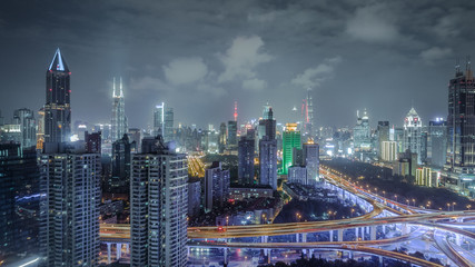 aerial view of buildings and highway interchange at night in Shanghai city