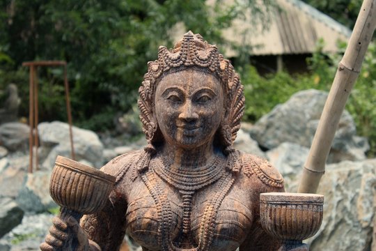 Beautiful/perfect sculpture of Dancing devadasi Holding musical instrument on her hand carved from red sand stone with natural background.An female servant of god or jogini is a girl.Odisha,July/7/18