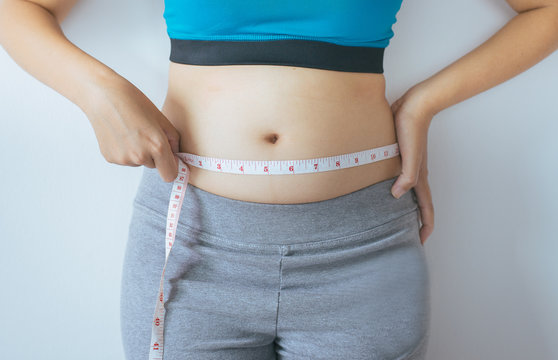 Woman measuring waist with  measuring tape,Excess belly fat and overweight fatty bellys of female