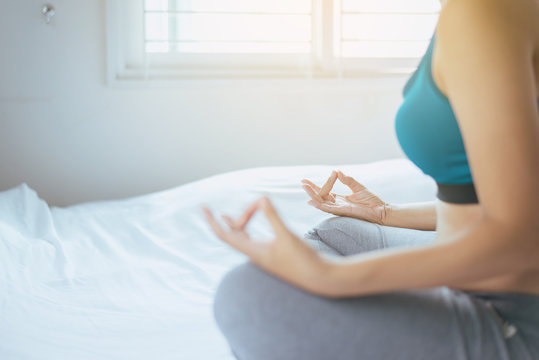 Woman practicing doing yoga exercise in bedroom
