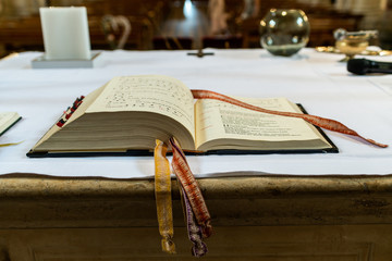 praying book on the altar in a church before wedding focused on the bible - obrazy, fototapety, plakaty