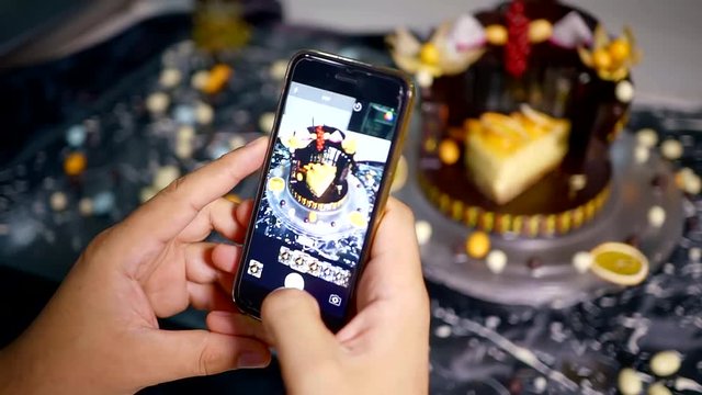 cook takes pictures on the smartphone prepared cake