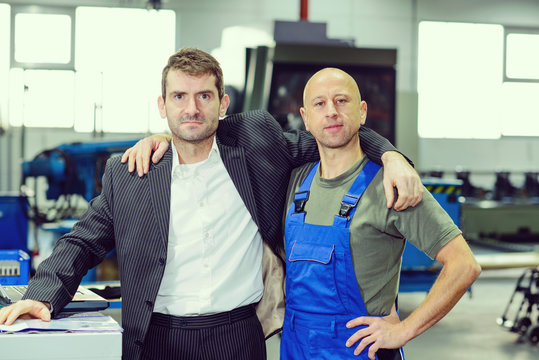 boss and worker on work bench- hugging