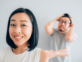 Happy Asian wife and angry loser husband.