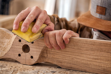 Experienced carpenter in work clothes and small buiness owner working in woodwork workshop,  using...