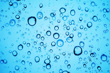 Fototapeta na wymiar Oxygen Bubbles in Water or Rain Drops on Glass Texture Background. Blue Tone