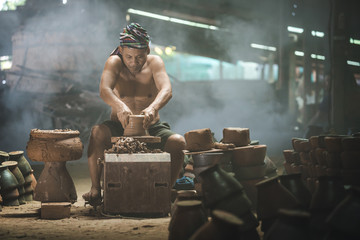 Thai old man using mechanic pottery made traditional earthenware in Ubon Ratchathani, Thailand