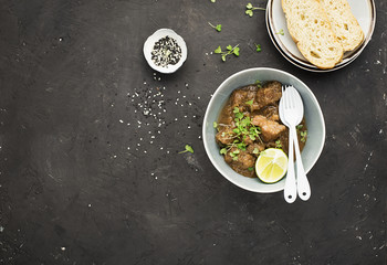 Homemade beef casserole served with rice, with juicy lime and micro greens portioned. Top View