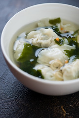 Bowl of chinese soup with wontons, close-up, selective focus, vertical shot