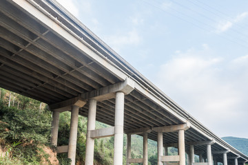 highway bridge through green hills