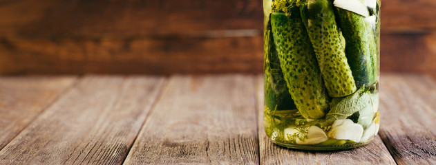 Salted Cucumbers in a Glass Jar on a Wooden Table, Canned, Vegetable Harvesting © yakovlevadaria