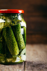 Salted Cucumbers in a Glass Jar on a Wooden Table, Canned, Vegetable Harvesting
