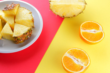 Pieces of pineapple on a white plate, chopped pineapple on a red yellow background, a salad of tropical fruits for breakfast, vegetarian food pop art