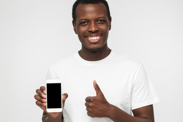 Closeup shot of young African American man isolated on white background wearing white t shirt,...