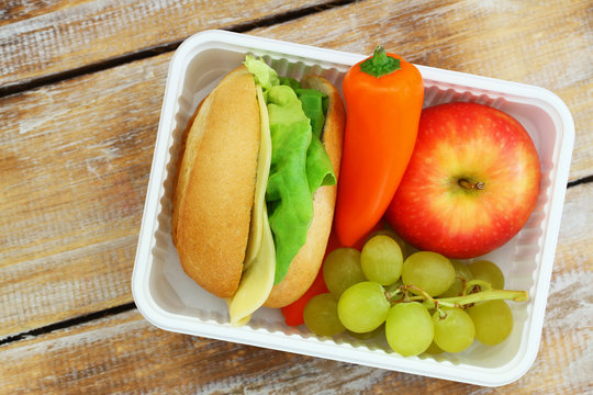Healthy lunch box with cheese roll, crunchy yellow pepper and fresh fruit
