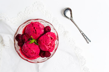Raspberry ice cream scoops in a bowl