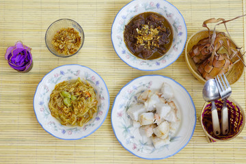 Rice cakes together with beef stew, chayote soup, unpeeled rice cakes and dried onion ares served  captured top view. 