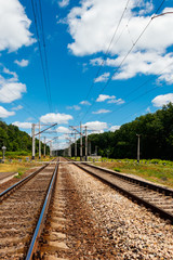 Scenic railroad in rural area and blue sky with white clouds in summer