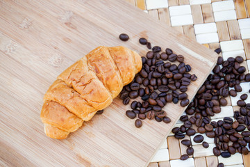 cup of coffee and croissants on wooden background