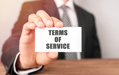 Businessman holding a card with text Terms of Service