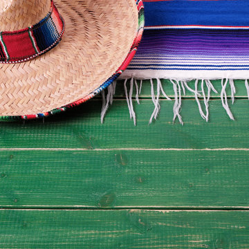Mexico cinco de mayo fiesta carnival traditional green wood background border mexican sombrero and serape rug or blanket photo square format