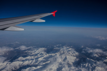 Fototapeta na wymiar airfoil in blue sky across mountains