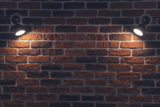 Old red brick wall with two spotlights. Rays in the center. Background texture closeup.