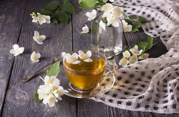 Obraz na płótnie Canvas Cup of fragrant flower tea with Jasmine, on gray surface