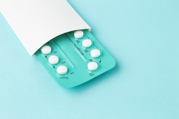 Pack of oral contraceptive pills with instructions. Blister in white case on blue background