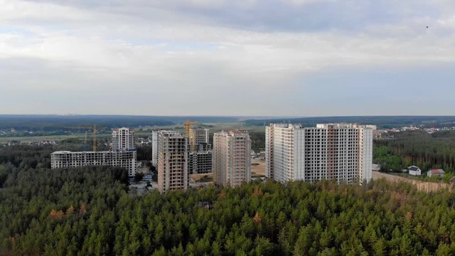 Building a city in the forest. Aerial survey of construction of a residential complex